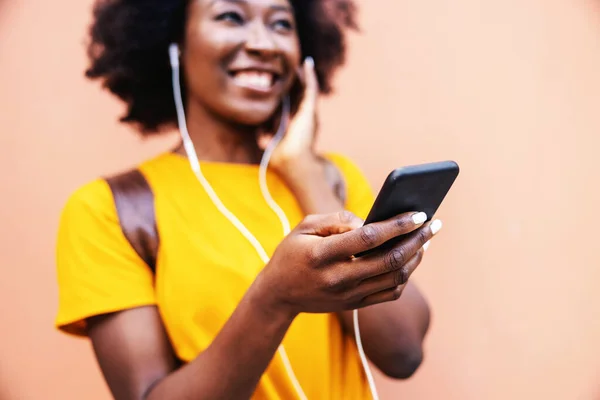 Jovem Sorrindo Atraente Mulher Africana Sorrindo Ouvindo Música Segurando Telefone — Fotografia de Stock