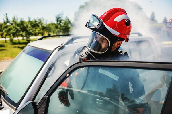 Bravo Bombeiro Entrando Carro Fogo Tentando Resgatar Vítima Acidente Cuidados — Fotografia de Stock