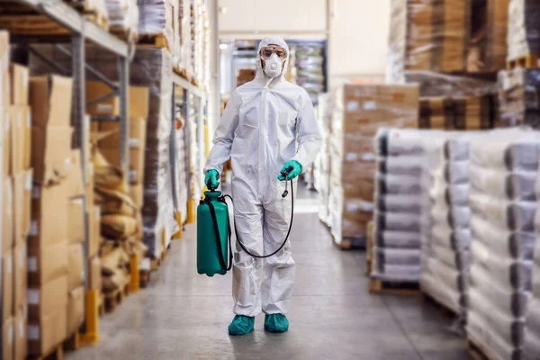 Hombre Con Traje Protector Máscara Desinfectando Almacén Lleno Productos Alimenticios —  Fotos de Stock