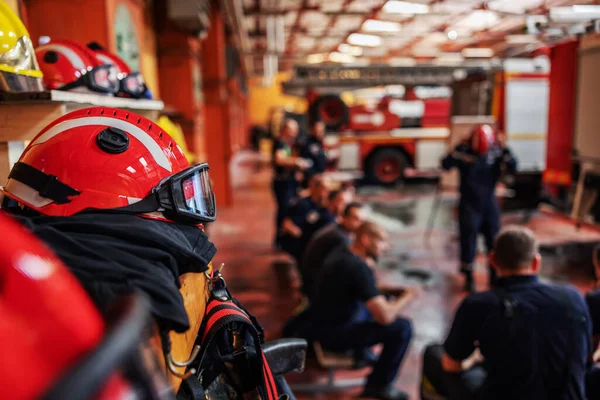 消防士が座ってるのを閉じてボスの話を聞いてる彼らがどうやって火を消すか戦術について話してる 消防隊のインテリア 防護服とヘルメットの閉鎖 — ストック写真