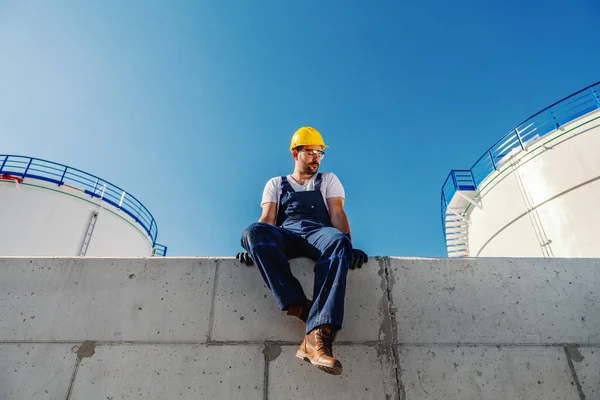 Tiefansicht Eines Kaukasischen Raffineriearbeiters Schutzkleidung Der Der Wand Sitzt — Stockfoto
