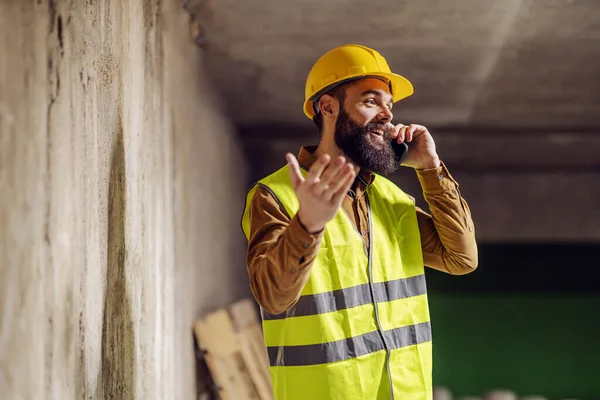 Genç Yakışıklı Sakallı Işçi Beton Duvarın Önünde Duruyor Akıllı Telefonla — Stok fotoğraf