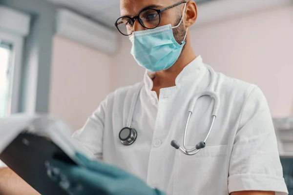 Fiatal Fókuszált Orvos Közelsége Gumikesztyűvel Sebészeti Maszkkal Steril Fehér Egyenruhás — Stock Fotó