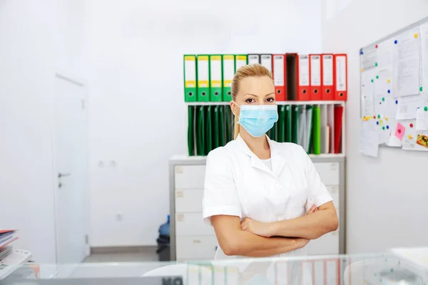 Atraktivní Pozitivní Blondýnka Laboratorní Asistentka Sterilní Uniformě Chirurgickou Maskou Stoje — Stock fotografie