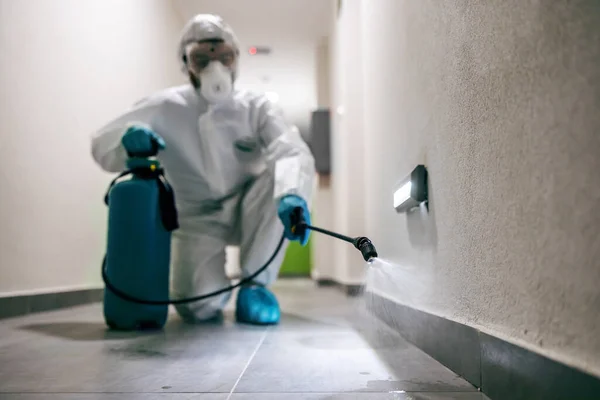 Worker Sterile Suit Mask Crouching Hall Building Sterilizing Corona Virus — Stock Photo, Image