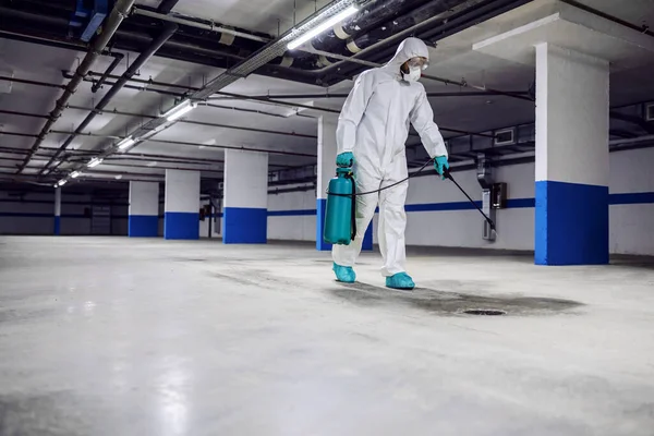 滅菌制服やマスク地下のガレージを歩くと表面を滅菌作業者 コロナウイルスからの保護 Covid 19の概念 — ストック写真