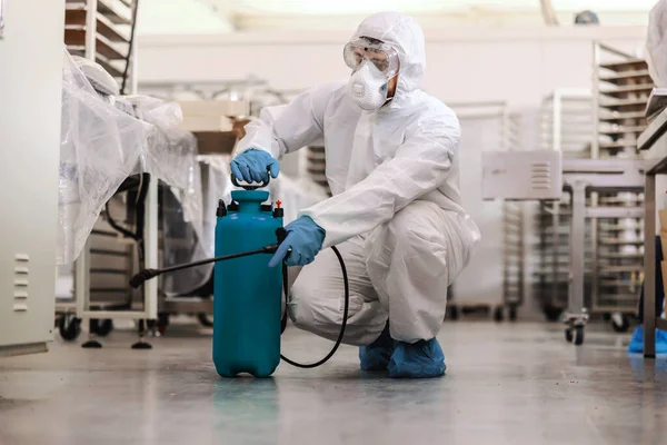 Arbeiter Schutzuniform Mit Maske Und Gummihandschuhen Hocken Und Sprühen Einer — Stockfoto