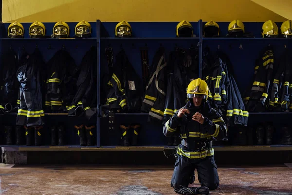 Jovem Bombeiro Corajoso Uniforme Protetor Ajoelhado Vestindo Capacete Cabeça Preparando — Fotografia de Stock