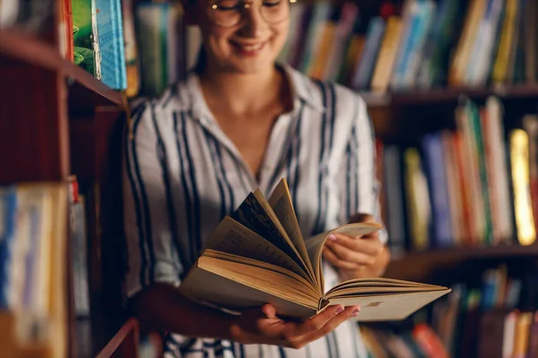 Młoda Uśmiechnięta Atrakcyjna Studentka Opierająca Się Półkach Książek Bibliotece Szukająca — Zdjęcie stockowe