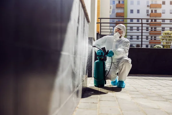 男性で滅菌制服とマスクを身に着けていると コロナウイルス 真菌や病気から屋外で表面をうずくまり滅菌 — ストック写真