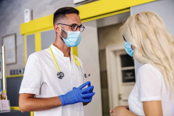 Mladý Lékař Gumovými Rukavicemi Obličejovou Maskou Sterilní Uniformě Stojící Nemocnici — Stock fotografie