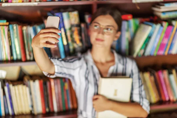 Joven Guapa Morena Vestido Con Anteojos Sosteniendo Libro Tomando Selfie —  Fotos de Stock
