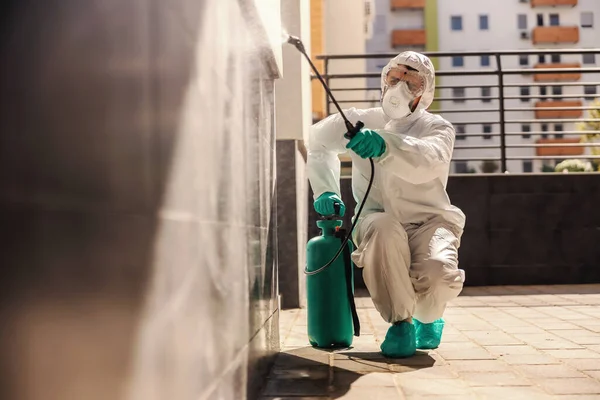 Homem Proteção Estéril Uniforme Agachamento Pulverização Parede Com Desinfetante Fim — Fotografia de Stock