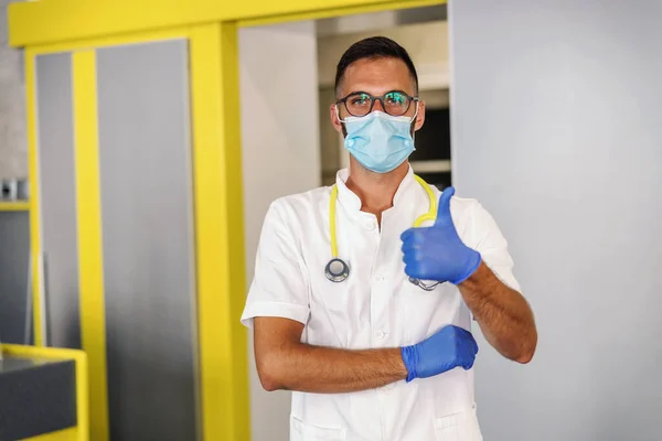 Fiatal Orvos Gumikesztyű Védőmaszk Steril Fehér Egyenruha Áll Kórházban Mutatja — Stock Fotó