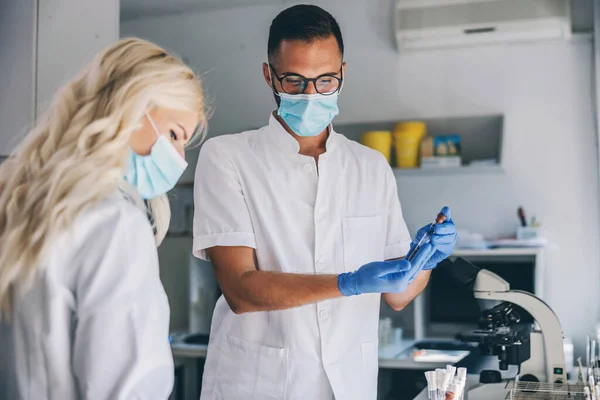 Dedikerad Erfaren Manlig Labbassistent Med Ansiktsmask Och Gummihandskar Stående Laboratorium — Stockfoto