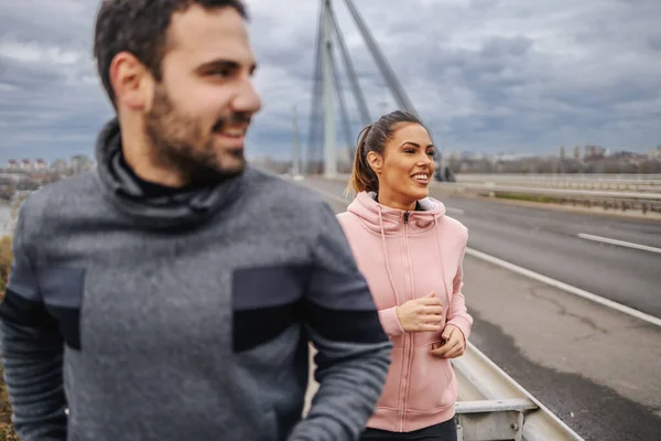 Genç Pozitif Gülümseyen Heteroseksüel Arkadaşlar Spor Kıyafetleriyle Bulutlu Havada Köprüde — Stok fotoğraf