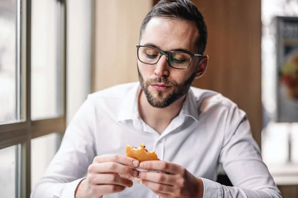 Joven Hambriento Elegante Hombre Sentado Restaurante Comida Rápida Comer Hamburguesa — Foto de Stock