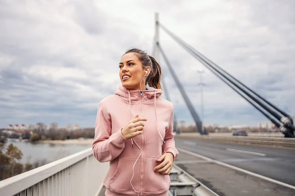 Sağlıklı Alışkanlıkları Olan Müzik Dinleyen Bulutlu Havada Köprüde Koşan Çekici — Stok fotoğraf