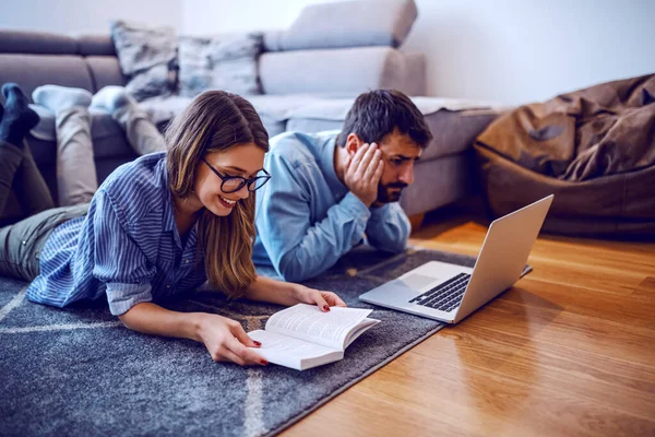 Jovencita Sonriente Alegre Tendida Suelo Leyendo Libro Interesante Mientras Novio — Foto de Stock