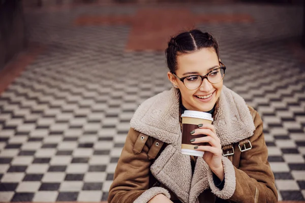매력적 미소짓는 여인이 바닥에 일회용 컵에서 커피를 마시는 — 스톡 사진
