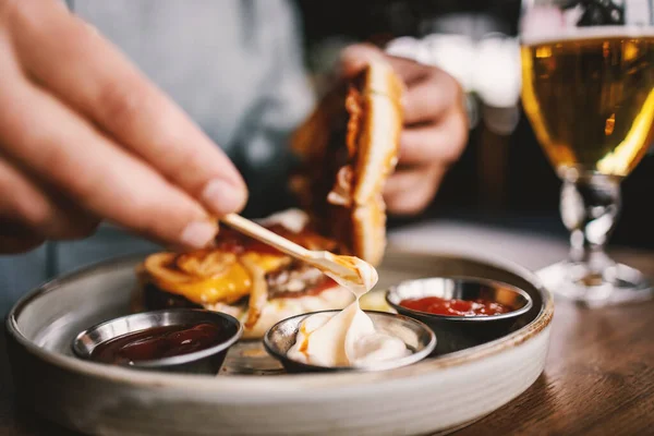 Primo Piano Uomo Seduto Nel Ristorante Mettere Maionese Hamburger — Foto Stock