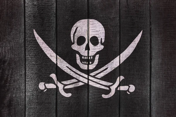 Calico Jack Pirate Flag on a wooden backgound. Pirates flags on wood texture. — Stock Photo, Image