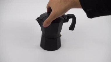 Using hand to close open the top and rotate a stovetop expresso coffee maker. isolated on white background