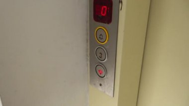Pressing the button with finger to call up the elevator on second floor close up