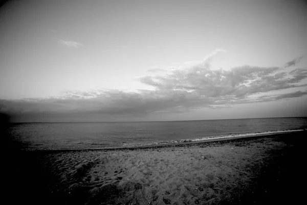 Morze lub ocean brzegu z chmur w czerni i bieli — Zdjęcie stockowe