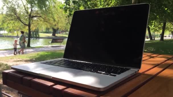 Vídeo Freelancer Laptop Close Uma Mesa Parque Com Pessoas Passando — Vídeo de Stock