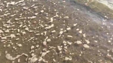 4k video Kumlu sahil veya okyanusta ezici veya sıçrayan çok sakin dalgaların görünümünü kapatın 