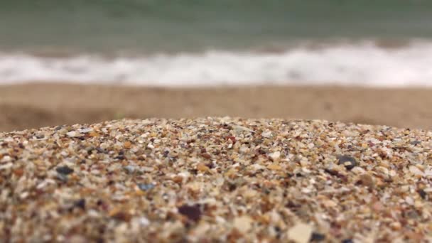 4Kビデオ 砂のクローズアップビューとぼやけたり 海の波が破砕したり ビーチの海岸や海に飛び散る — ストック動画