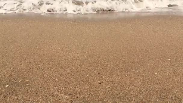 4Kビデオ 砂浜の海岸や海に押しつぶされたり 水しぶきが飛び散る穏やかな波のビューを閉じます — ストック動画