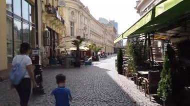 Bükreş, Romanya - 20 Haziran 2020: 4 km uzunluğunda Romanya 'nın Bükreş kentindeki Old Town veya Old Center' da yürüyüş videosu. Lipscani sokağı insanlarla yürüyor, eski mimari, teraslarda tatil yapan insanlar.