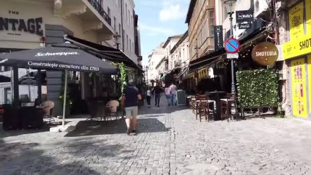 ルーマニアのブカレスト 2020年6月20日 ルーマニアのブカレストの旧市街や旧市街を歩く4Kビデオ リプスカニ通りの人々 古い建築物 テラスで休暇を楽しんで人々と歩く — ストック動画