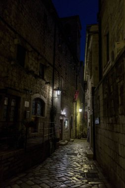 Buildings in night in narrow street in scenic cityscape in Montenegro clipart