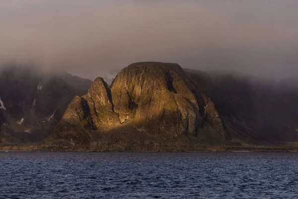 Rock with snow in sea