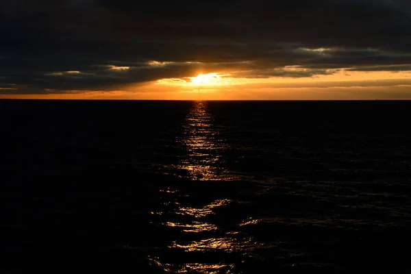在黑暗的日落中 在水中反射阳光的海景风光 — 图库照片