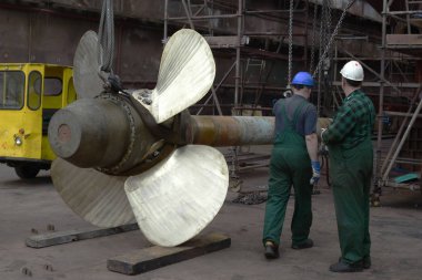 Polonya, Szczecin - 27 Mayıs 2016: İşçi kuru iskeledeki yarda tamir gemide gemi pervane yüklemek