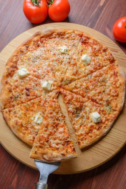 Pizza dilimlenmiş ahşap tahta üzerinde