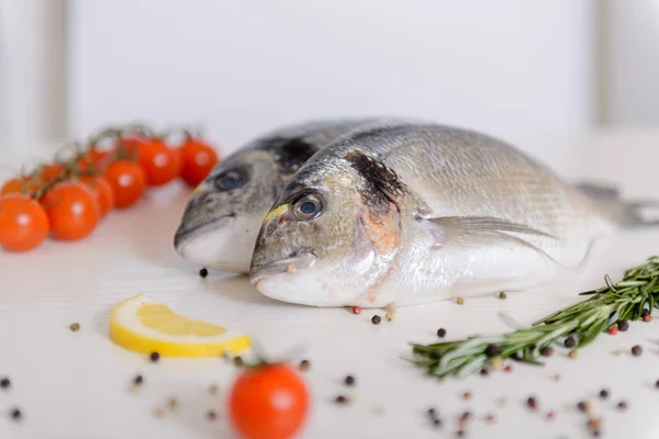 Due Pesci Dorada Freschi Con Pomodorini Rosmarino Limone Pepe Fondo — Foto Stock