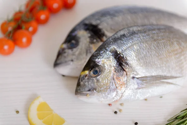 Due Pesci Dorada Freschi Con Pomodorini Rosmarino Limone Pepe Fondo — Foto Stock