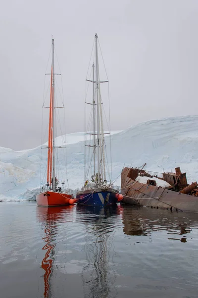 Twee Zeiljachten Antarctische Wateren Zee Afgemeerd Naar Roestig Wrak — Stockfoto