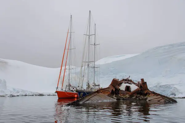 Twee Zeiljachten Antarctische Wateren Zee Afgemeerd Naar Roestig Wrak — Stockfoto