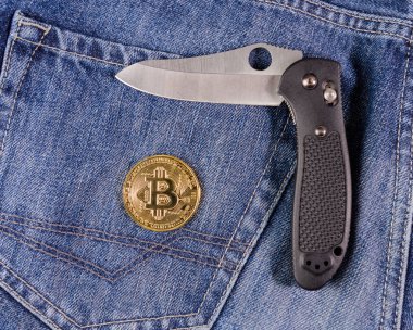Katlama bıçak ve altın bitcoin sikke üzerinde kot artalanları
