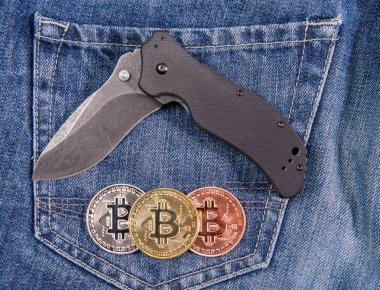 Bıçak ve üç bitcoin sikke üzerinde kot artalanları katlama
