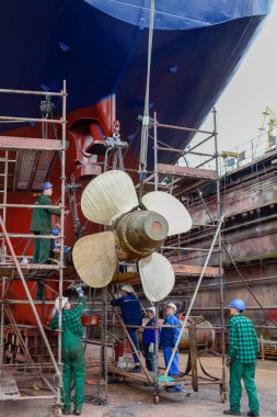 Polonya, Szczecin - 27 Mayıs 2016: İşçi kuru iskeledeki yarda tamir gemide gemi pervane yüklemek