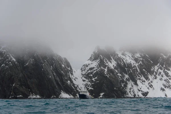 Rock with snow in sea