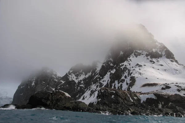 Rock with snow in sea