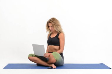 Beyaz arka plan üstünde laptop Yoga yapıyordum güzel genç kadın